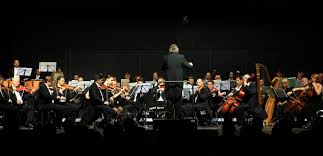 Dirigent Hans Richter mit seinem Orchester gibt den Auftakt.